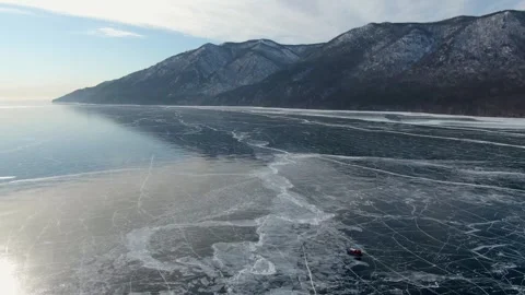 Peaceful Portrayal Of Single Red hovercraft Traveling Across Icy Lake Surface Stock Footage 339184505