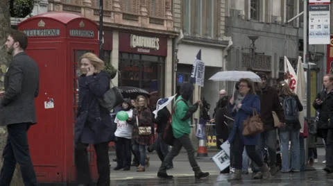 Peaceful protestors pass a phonebox Stock Footage 36622339