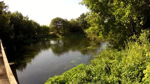 Peaceful River With Bridge - Sun Flickering Through Trees Stock Footage 12142289