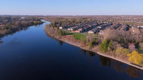 A peaceful river meanders through the landscape flanked by a suburb Stock Footage 274127480