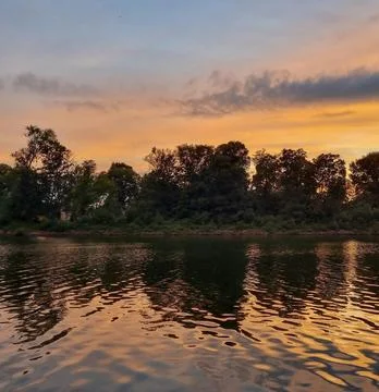 Peaceful River Scene with Trees Under Clear Sky Stock Photos