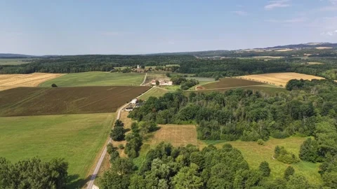 Peaceful rural landscape with patchwork fields, winding country road, Stock Footage 348504261