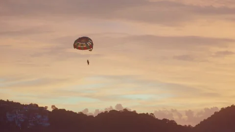 Peaceful scene of parasail gliding over tranquil ocean at dusk. Serene image of Stockbeeldmateriaal 338088147
