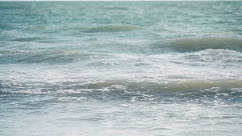 Peaceful slow motion view of small turquoise waves lapping sandy beach Stock Footage 119534668