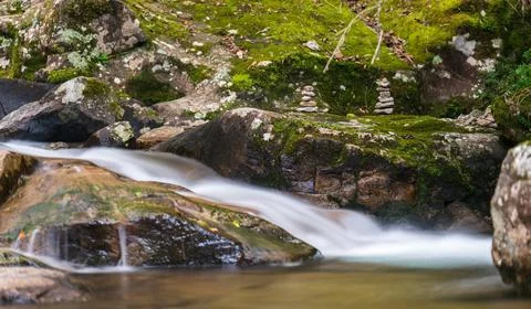 Peaceful Stone Marked Path Along Serene River 스톡 사진