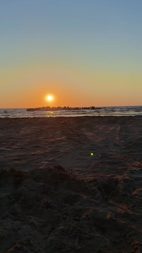 Peaceful sunset beach view with orange glow and soft waves Stock Footage 311831103