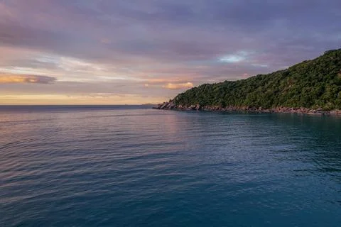 A peaceful sunset drone shot casts warm hues over serene tropical waters. Stock Photos