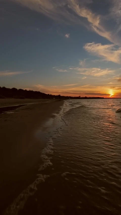 A peaceful sunset over a calm beach in Jurmala, Latvia, with gentle waves Stockbeeldmateriaal 287317898