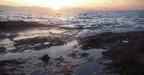 Peaceful sunset over calm ocean waters and rocky coastal tidepools. Stock Footage 337408290