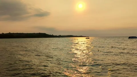 A peaceful sunset over the ocean with an orange sky and reflections on the water Stock Footage 276602331