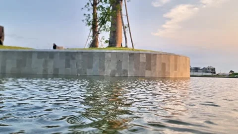 Peaceful Sunset Reflection on Modern Garden Pond with Gentle Water Ripples Stock Footage 332784703