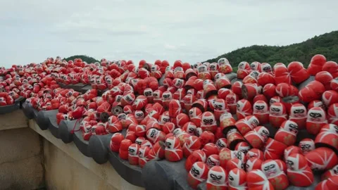 Peaceful view of red and white Daruma dolls at Katsuoji Temple, surrounded by Stock Footage 344278769