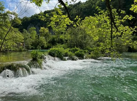 Peaceful Waterfall Flowing Over Rocks Surrounded by Lush Greenery Stock Photos