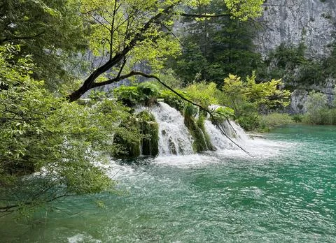 Peaceful Waterfall Flowing Over Rocks Surrounded by Lush Greenery Stock Photos