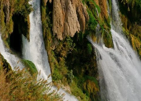 Peaceful Waterfall Flowing Over Rocks Surrounded by Lush Greenery Stock Photos