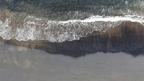 Peaceful waves roll into a black sand beach shore paradise Stock Footage 103222205