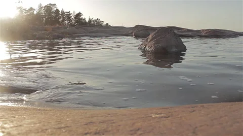 Peaceful waves rolling in to rocky shore during sunset - 1920x1080 24p Stock Footage