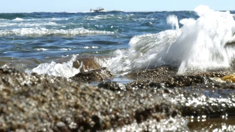 Peaceful waves splashing on stony beach - 4k Stock Footage 81732575