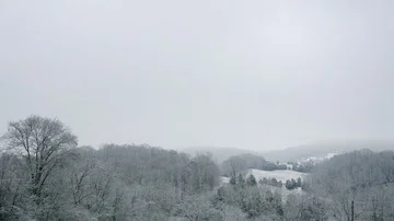 A Peaceful Winter Scene of Snow Covered Rolling Hills and a Grey Sky in 4K Stock Footage 85707343