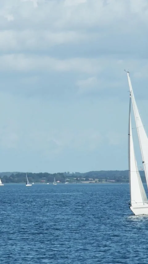 A peaceful yet energetic vertical time-lapse of sailboats navigating the ope 库存影片 334052063