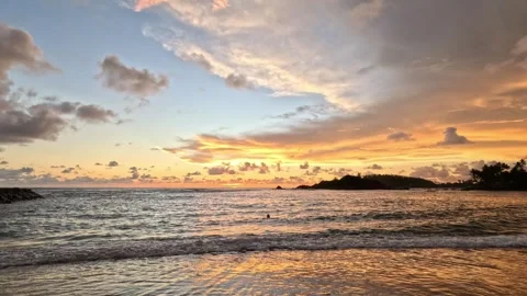 Peach-colored clouds over calm waves with people watching sunset in Sri Lanka 스톡 동영상 339904953