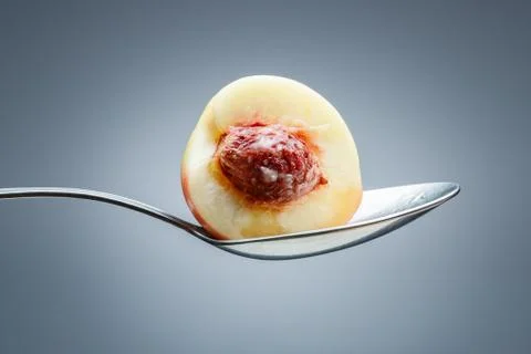 Peach on curved spoon Stock Photos