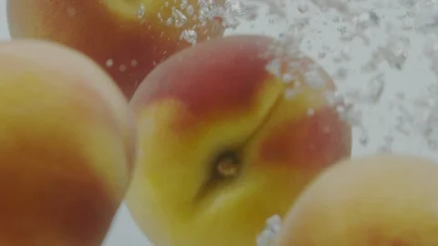 Peach falling in water Stock Footage 98299974