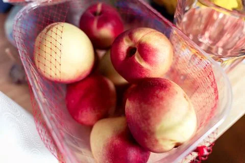 Peach fruit in a plastic box, kitchen mess Stock Photos