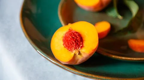 Peach in half with bone. Rustic minimalist food peach fruits with leaves on Stock Photos