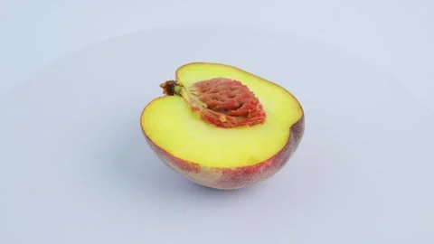 Peach half rotates on white background. Fresh fruit presentation 4k 動画素材 342964049