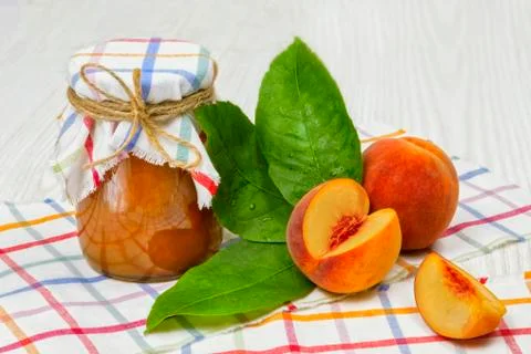 Peach jam in the jar on the table Stock Photos