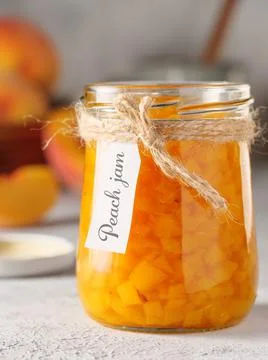 Peach jam on a light background. Copy space, vertical photo. Stock Photos