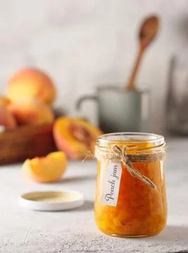 Peach jam on a light background. Copy space, vertical photo. Stock Photos