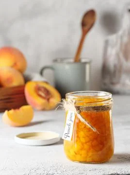 Peach jam on a light background. Copy space, vertical photo. Stock Photos