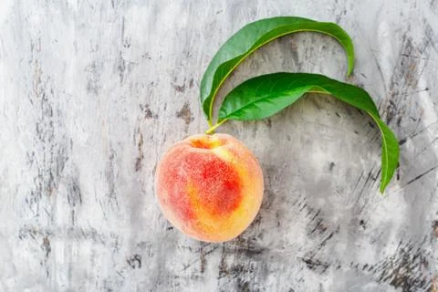 Peach with leaf on gray concrete background. Fresh sweet peach with pitted. T Stock Photos