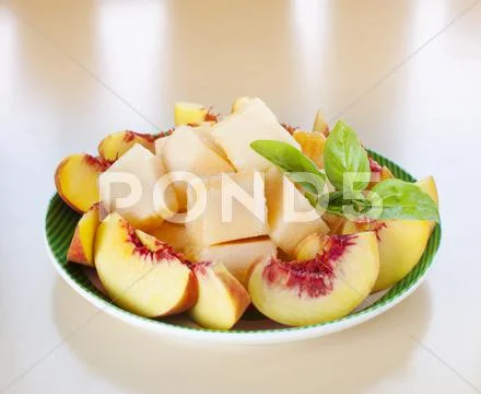 Peach melon sliced basil plate Stock Photos