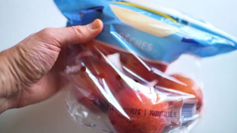 Peach peaches fruit in plastic bag macro closeup hand holding package Vidéo 330175896