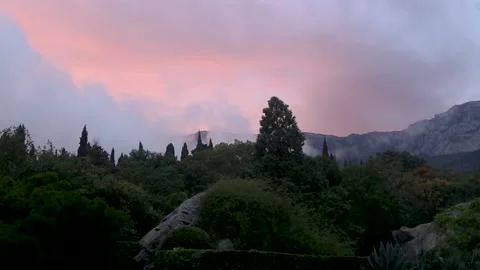 Peach-pink sunset against a background of high mountains and trees Stock Footage 164654347