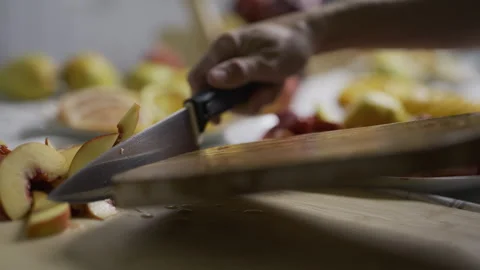 Peach slices being pushed off cutting board by knife onto another board - slow Stock Footage 341027438