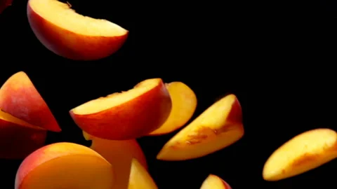 Peach slices fly close-up on a black background Stock Footage 97266828