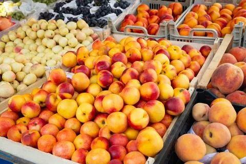 Peaches of different types in boxes at a local market. Colorful display Stock Photos