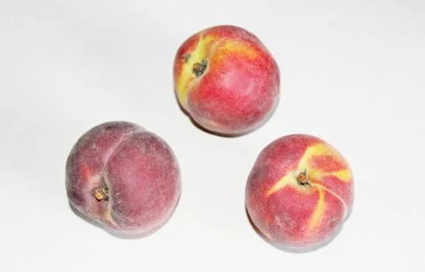 Peaches lying on the table on a white background Stock Photos