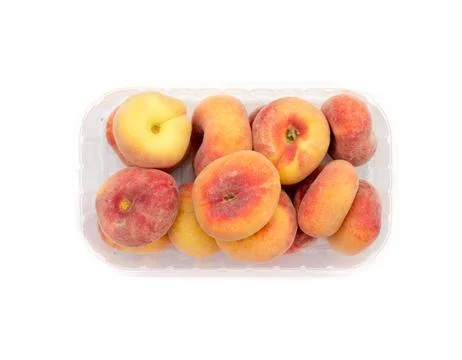 Peaches in a plastic container. Stock Photos