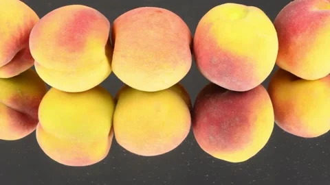 Peaches in a row on a black mirror. Loop motion. Side view. Rotation 360. Stock Footage 161242115