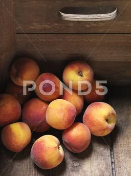 Peaches Stacked In Corner Of Wooden Box