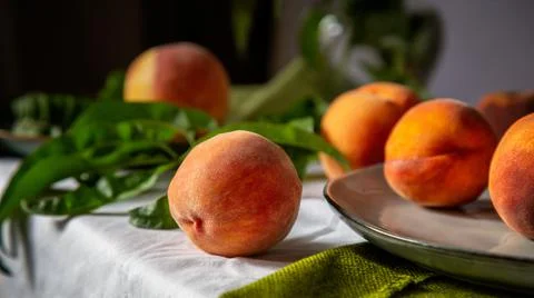 Peaches on table in kitchen near window. Rustic minimalism food peach fruits  Stock Photos