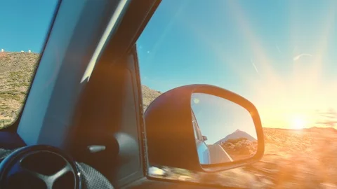 Peak of a volcano mountain reflected in the rear view mirror of a car while Stock Footage 119533980