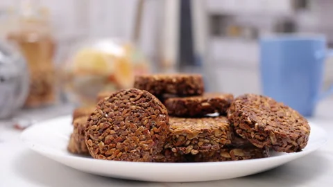 Peanut Brittle Or Sweets Kozinaki On White Plate On Kitchen Table With A Blue Cu Stock Footage 148502016