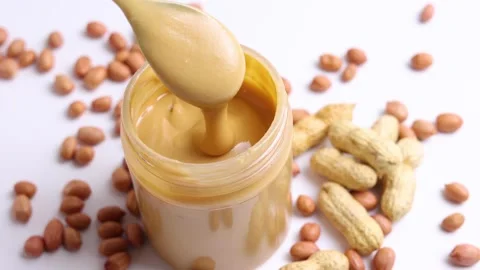 Peanut butter and raw peanuts on a light background Stock Footage 239865134