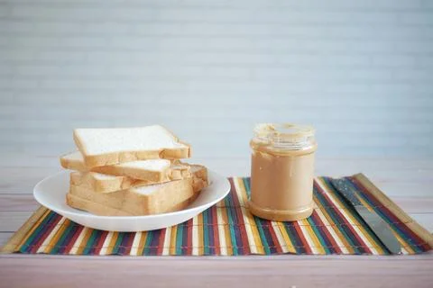Peanut butter and stack of bread on table with copy space 스톡 사진